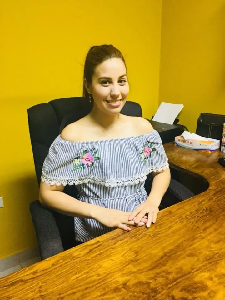 Reyna Isabel Gutierrez Pierce se encuentra sentada en su oficina sonriendo a la camara.